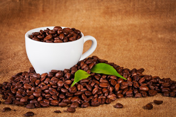 coffee cup and arabica beans on cloth sack