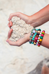 Close-up of sand heart in woman's hands decorated with colorful