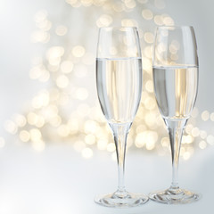 Two champagne flutes on gold shiny background