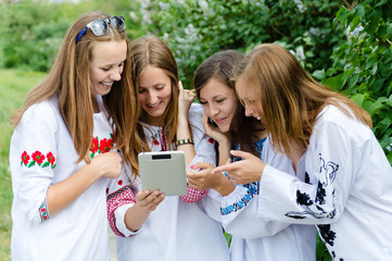 Fototapeta premium Four happy teen girl friends and tablet computer