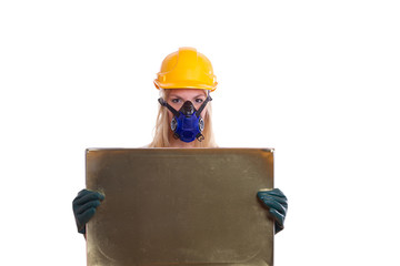 Frau mit Helm und Atemschutz hält ein Schild
