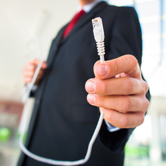 Young businessman holding an ethernet cable