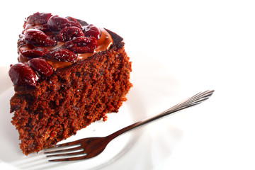 Piece of chocolate cake with icing and cherry
