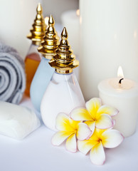 Three Plumeria flower with massage oil and balsam in bowl 
