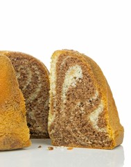 A slice of a marble sponge cake on a white background