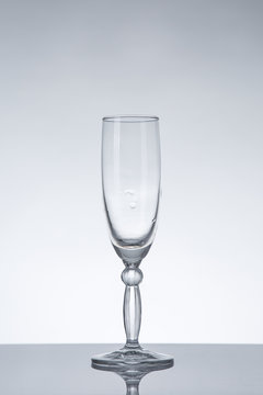 Empty champagne glass on grey background