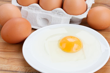 raw eggs and broken one on plate