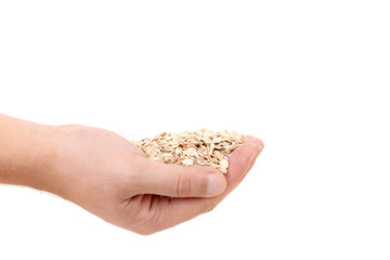 Oatmeal flakes into hand.