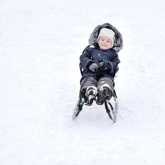 Fototapeta na wymiar Boy sliding on snow - outdoors