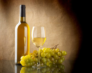 Bottle of wine and a bunch of white grapes