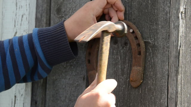 man hand fastened with two nails horseshoe down symbol happiness