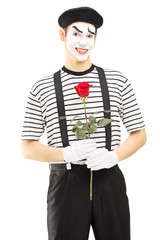 Male mime artist holding a rose flower