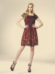 Fototapeta premium young girl standing in elegant dress against gold background