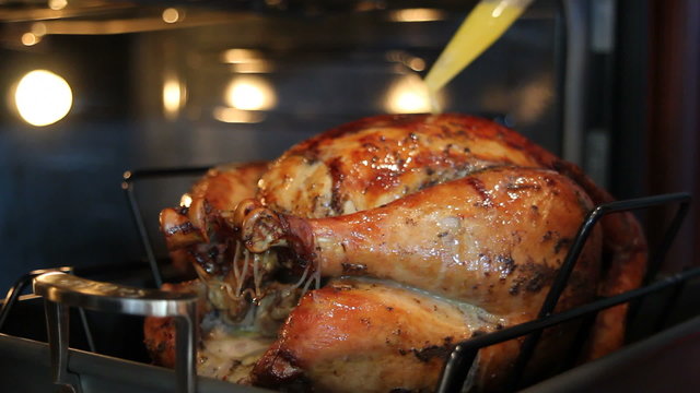 Basting a Seasoned Whole Turkey with Melted Butter