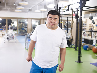 Fototapeta na wymiar portrait of an overweight young man standing in gym
