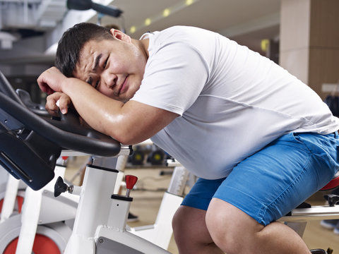 overweight man exhausted in gym