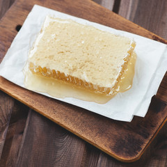 Above view of a honeycomb on a wooden cutting board, studio shot
