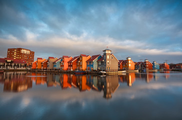 Fototapeta na wymiar colorful buildings on water during sunrise, Holland