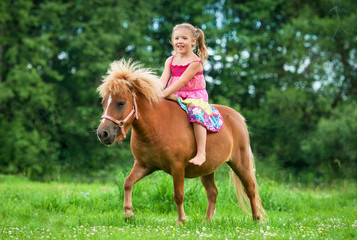 Little girl riding little pony