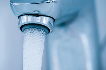 Tap closeup with leaking water stream.