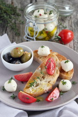 Roasted bread with tomato, mozzarella and olives.