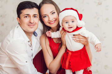 Happy family with cute baby in suit of Santa's little helper