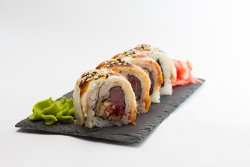 Sushi roll on stone plate isolated on white background