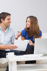 Fototapeta na wymiar Smiling couple paying their bills online at home
