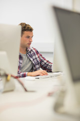 Focused handsome student studying in the computer room