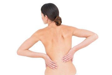 Rear view of a fit topless young woman with back pain