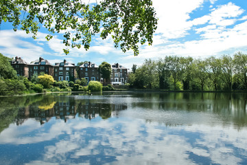 Fototapeta na wymiar reflection of sky in hampestead heat lake with buildings