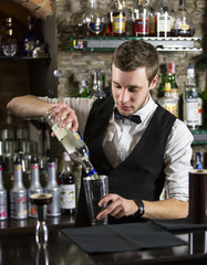 young man working as a bartender in a nightclub bar