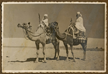 CIRCA 1960 - child and his mother sitting on a camel