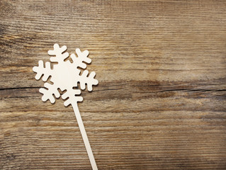 Snowflake shape made of wood on rough wooden background