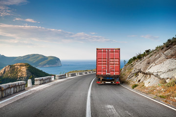 Cargo truck on the mountain highway with blue sky and sea