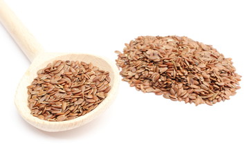 Heap of linseed with wooden spoon on white background