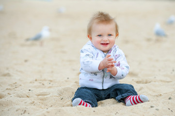 Little Kid on Sand Beach and Seagulls