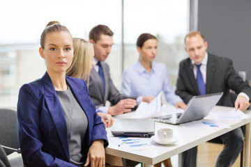 Fototapeta premium businesswoman in office with team on the back