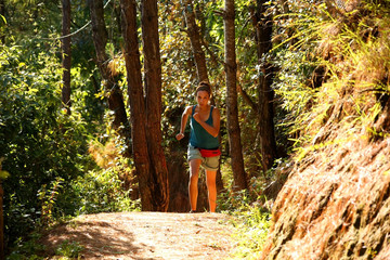 Sexy girl running along narrow footpath in forest