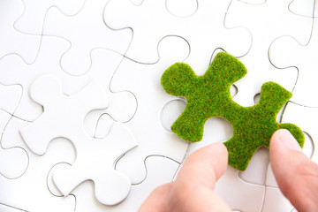 hand holding a green puzzle piece