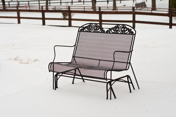 Fototapeta na wymiar Metal bench in backyard snow