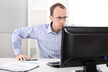 Verärgerter Mann unter Stress im Büro vor dem PC