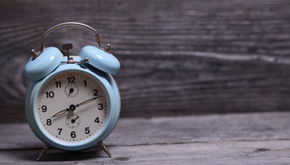 Retro turquoise clock on wooden background