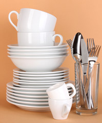 Clean white dishes on beige background