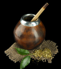 Calabash and bombilla with yerba mate isolated on black