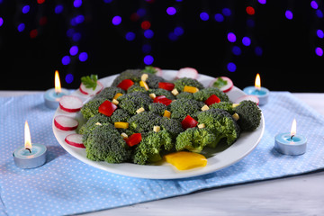 Fototapeta na wymiar Christmas tree from broccoli on table on dark background