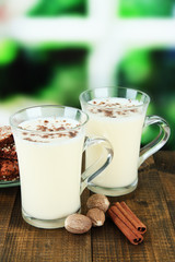 Cups of eggnog with cinnamon and nuts