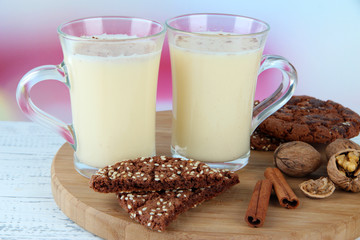Cups of eggnog with cinnamon and cookies