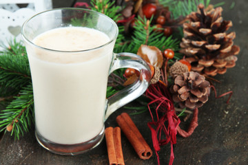 Cup of eggnog with fir branches and Christmas decorations