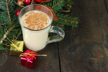 Cup of eggnog with fir branches and Christmas decorations